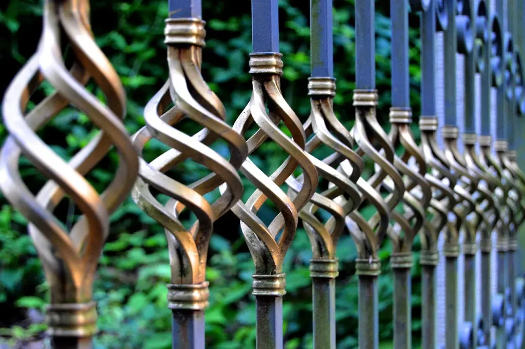 Wrought iron fence posts with spiral design and brass paint