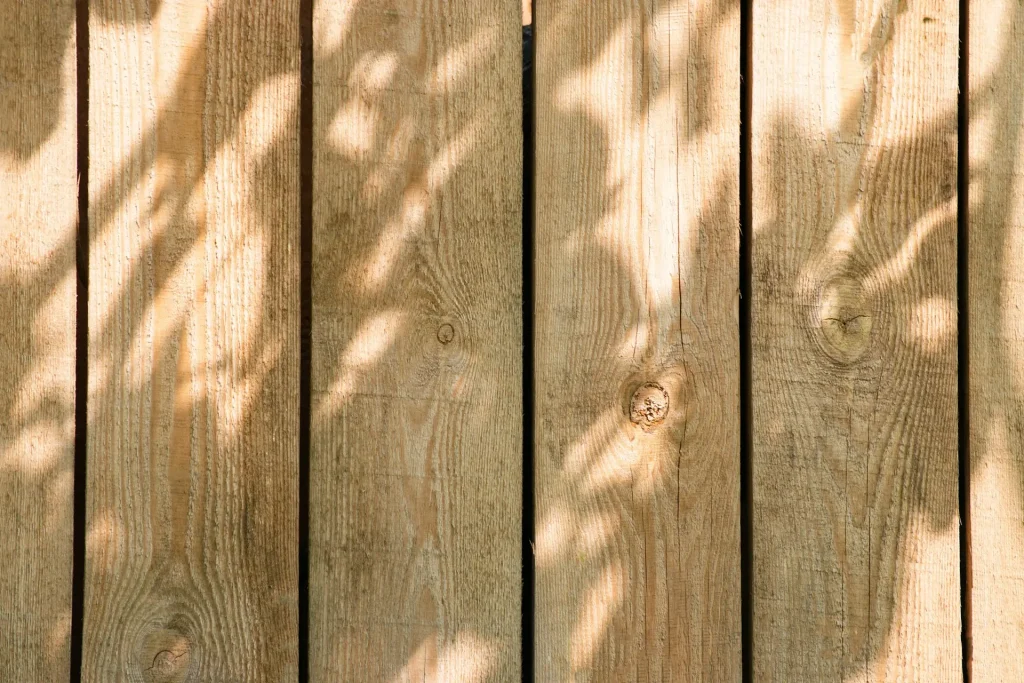 Close up of wooden fence boards with shadow of a tree